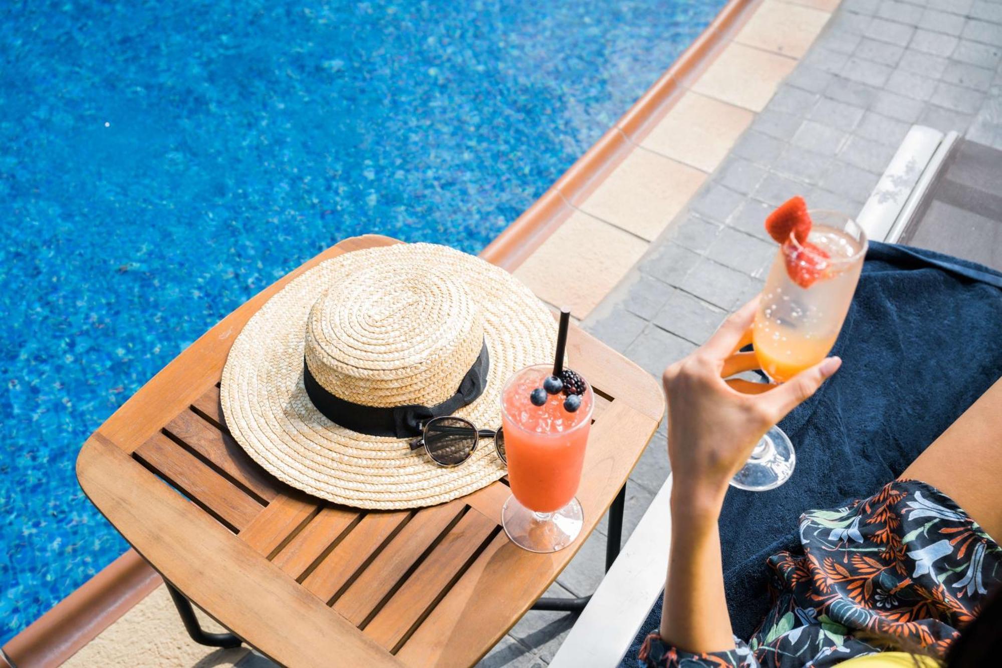 Отель Hilton Доха Экстерьер фото A woman holding a cocktail