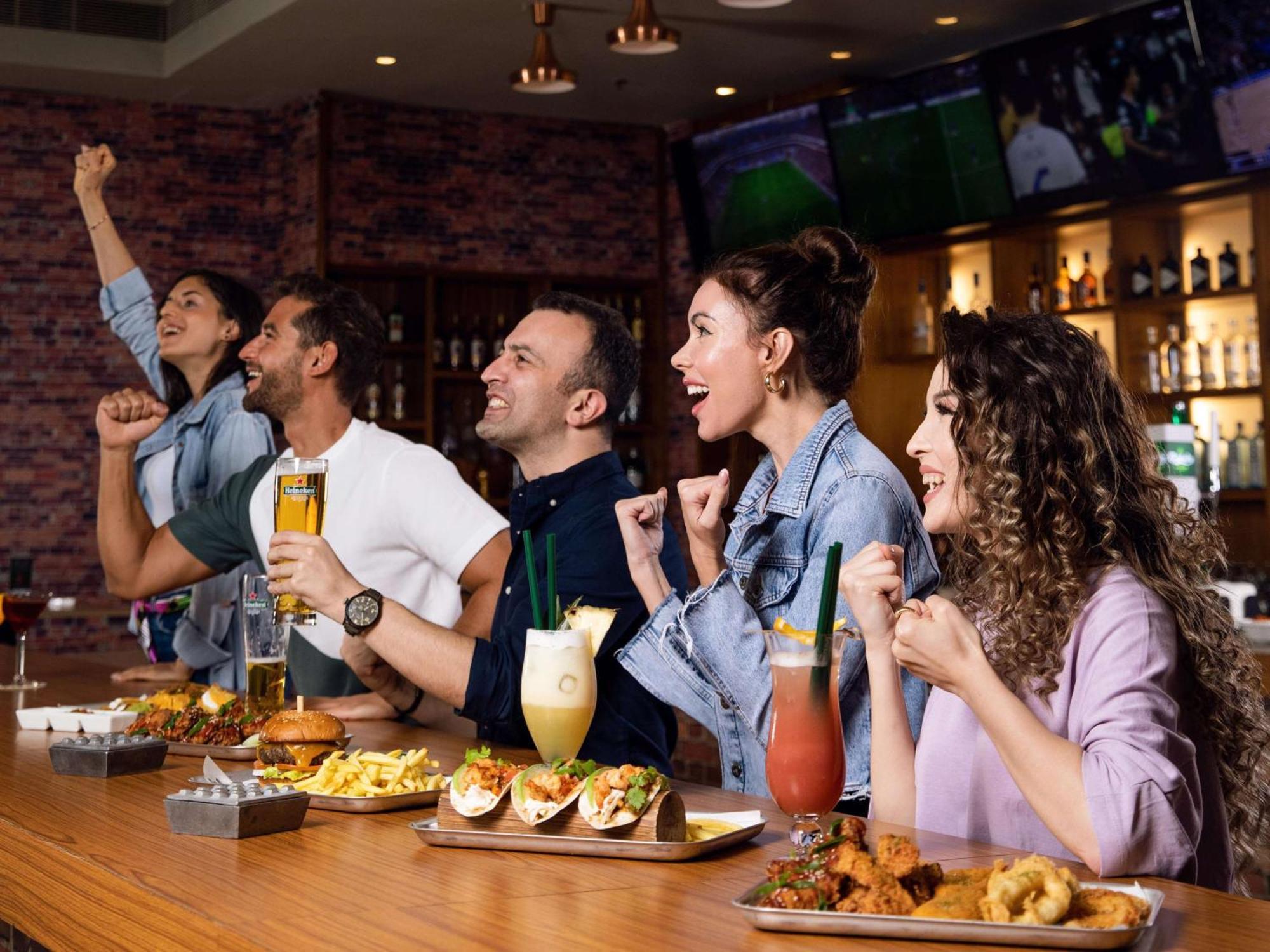 Отель Hilton Доха Экстерьер фото People watching a game at a sports bar